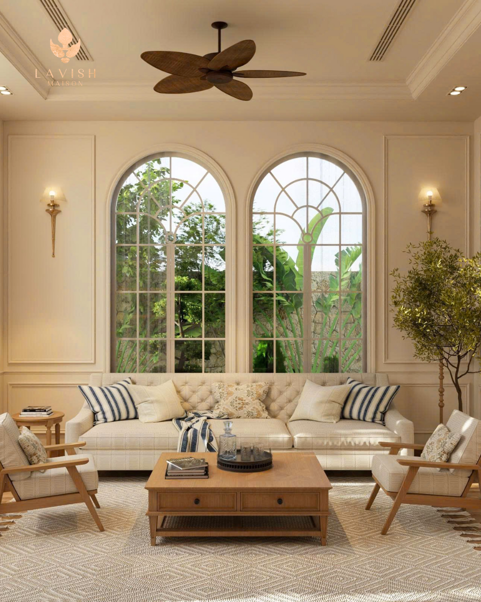 Phòng khách phong cách Transitional Farmhouse với tường ốp gỗ màu xanh, tranh treo tường, đèn chùm cổ điển và bàn gỗ trang trí, sử dụng tông màu trung tính ấm áp.